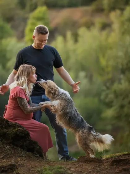 A playful lick from an excited big-brother-to-be! This candid moment captures the joy and anticipation of the whole family, furry members included, during a forest maternity shoot.
