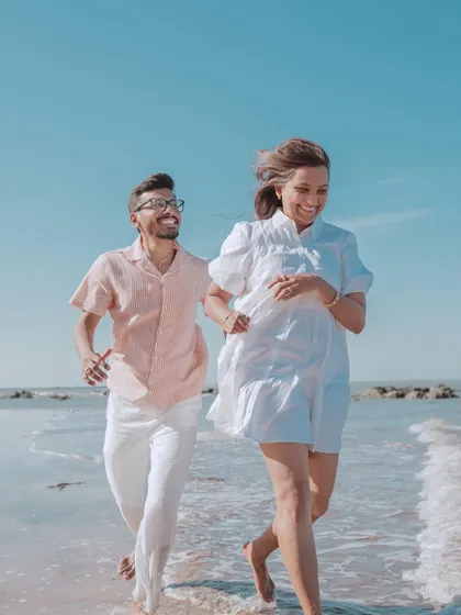 A duplicate of image 113, this candid shot shows Harsh and Shreya running along the shoreline, full of life and happiness.