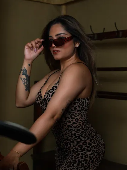 A close-up portrait of the model in sunglasses, exuding confidence and style.