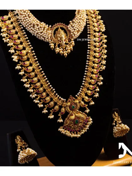 A complete bridal set featuring a Ganesha choker and a long mango mala. This combination is both traditional and unique.