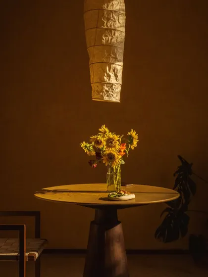 A vase of sunflowers catches the last rays of the day, bringing warmth and color to the minimalist interior.