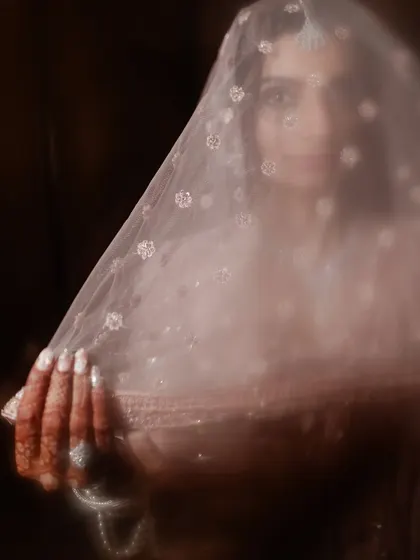 An artistic, soft-focus shot of the bride through her veil, creating a dreamy and ethereal portrait.