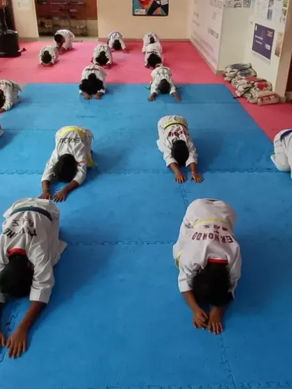 Students perform forward-bending stretches to improve hamstring flexibility and core strength.