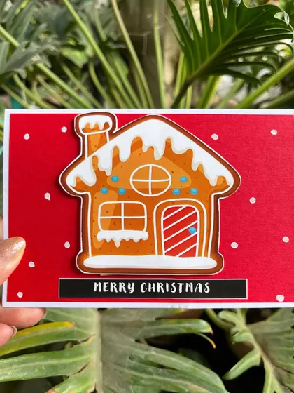 This gingerbread house card is another one of our festive favorites. The intricate details and snowy icing make it a delightful holiday greeting.