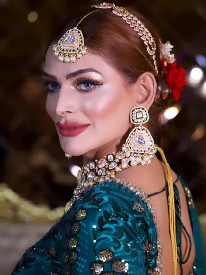 A beautiful close-up of the celebrity look, with a red rose in her hair. The details, from the perfectly blended skin to the crisp red lip, are what make this look special.