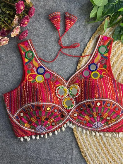 A red version of my popular fan-design blouse, this piece features vibrant embroidery, mirror work, and a delicate cowrie shell border.