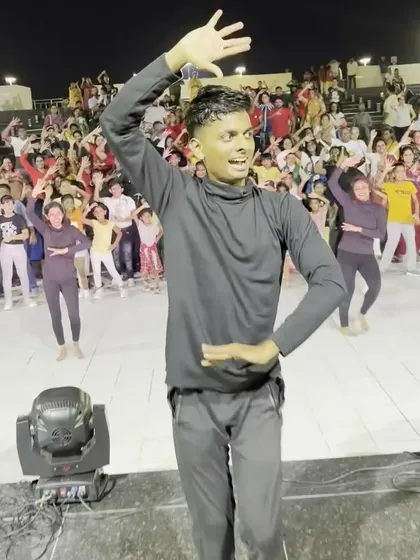 An instructor leads a flashmob, with a massive crowd of students and onlookers dancing along. These events bring our entire dance community together.