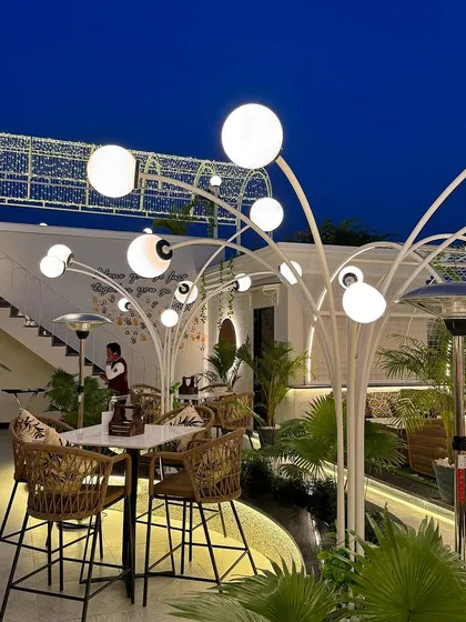 A wider view of the custom lighting on the Tipsy Town rooftop. The glowing orbs on branching white structures create a magical forest effect at night, making the space feel enchanting and memorable.