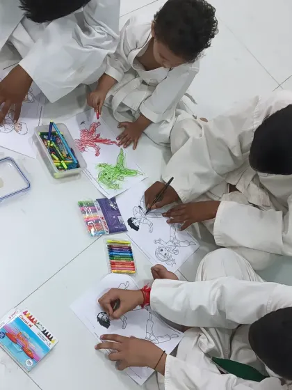 A group of boys working together on their coloring pages. It's a peaceful end to an energetic karate session.