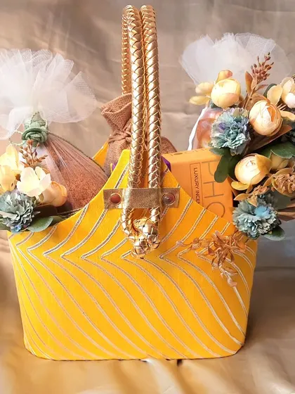 This vibrant yellow fabric basket is a perfect solution for all your festive gifting needs. It's filled with treats and decorated with floral accents, suitable for Diwali, Ganpati, and other celebrations.