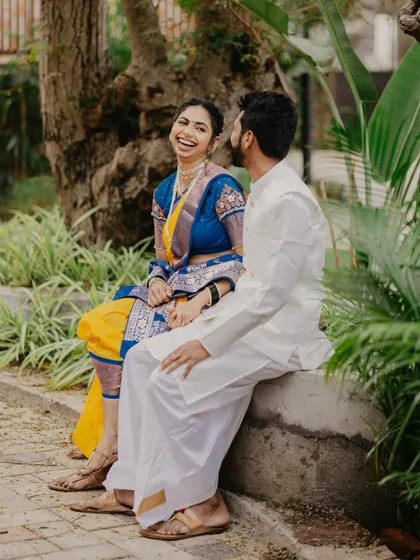 A candid laugh shared between the couple while sitting on a park bench, showcasing a genuine moment from their pre-wedding shoot.