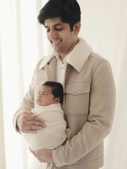 A father's gentle hold. This portrait captures the peacefulness of a sleeping newborn cradled in his dad's arms, a moment of pure serenity.