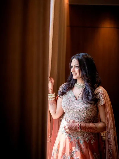 The bride-to-be gazes out a window, captured in a moment of quiet anticipation.