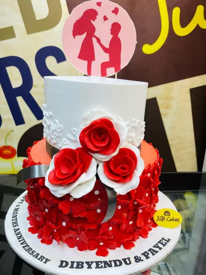 A romantic 3kg two-tiered anniversary cake with red petal details and a "proposal" silhouette topper.