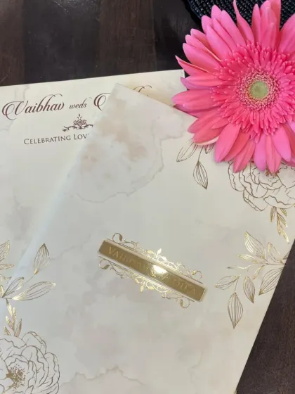 A closer look at our floral invitation card, featuring delicate line art flowers with gold foil accents and a custom nameplate.