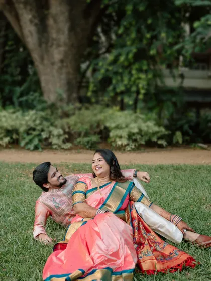 A wider angle of the couple relaxing on the grass, capturing the peaceful park setting. This photo shows the relaxed and comfortable atmosphere of my outdoor photoshoots.