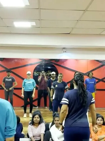 An instructor leads a rehearsal from the audience's perspective. This gives a sense of the scale and coordination required for our large group numbers.