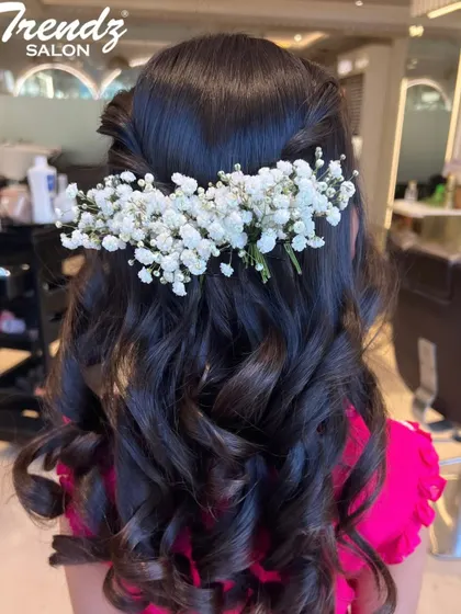 A romantic and elegant hairstyle for a special occasion. These soft curls are adorned with a beautiful arrangement of baby's breath flowers.