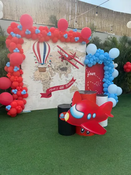 An "Up and Away" aeroplane theme for a little traveler's birthday, featuring a world map backdrop and vintage plane props.