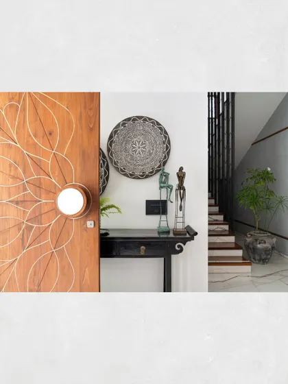 A detail of the entryway in Kamala Residence, showing the custom-designed main door with its intricate inlay and unique handle, alongside traditional art pieces.