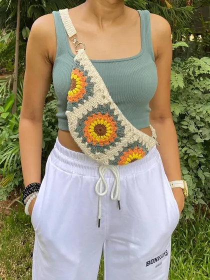This is our sunflower granny square fanny pack in a beautiful cream colorway. It’s a softer, more neutral option that still has that pop of floral fun.
