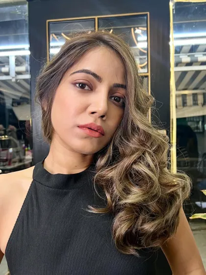 A close-up of the finished ash blonde balayage, styled into glamorous waves. The blend of colors is seamless and sophisticated.