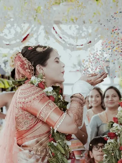 The bride's turn to shower the groom with rice. This action shot captures the fun and reciprocity of the talambralu ritual, with family looking on with smiles.