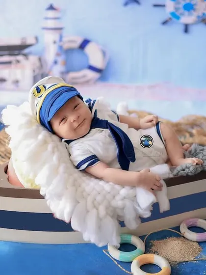 Ahoy, little captain. This sailor-themed newborn shoot is a perfect example of a fun, creative session for a baby boy. From the tiny sailor outfit to the boat prop and nautical background, every detail is planned.