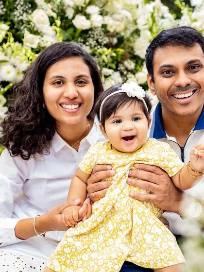 A joyful family portrait in black and white. Their bright smiles show the happiness of celebrating their daughter's milestone together.