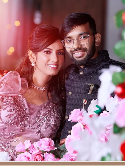 A sweet couple portrait from a reception or engagement party, framed by flowers.
