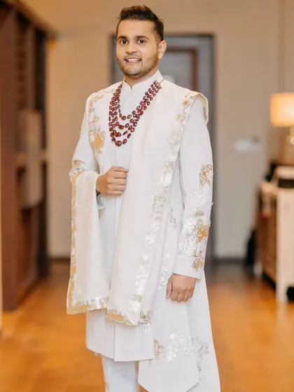 The groom looking sharp and elegant in his white sherwani, a perfect blend of modern style and traditional grace.
