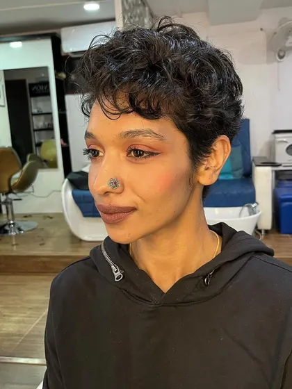 This angle shows the texture and detail of the curly pixie cut.