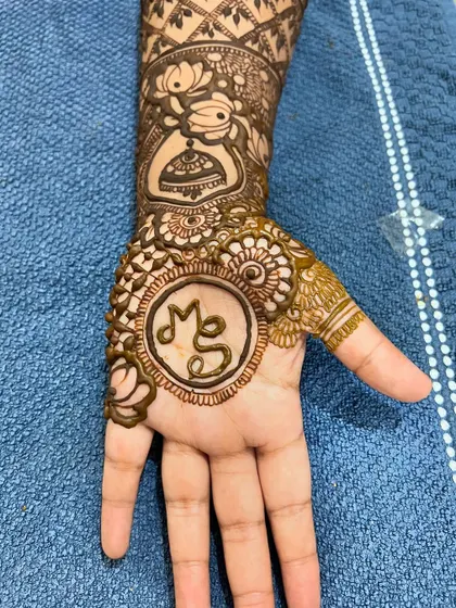 A close-up of the back of the hand, featuring the couple's initials 'MS' in a circle.