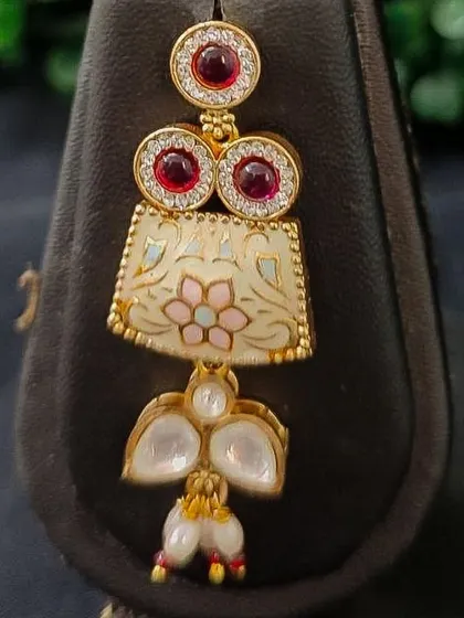 A close-up of the earring from this set, showing the beautiful floral enamel detail.