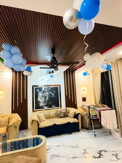 Another view of the living room decorated for a 'Welcome Baby' party, showing balloons floating on the ceiling.