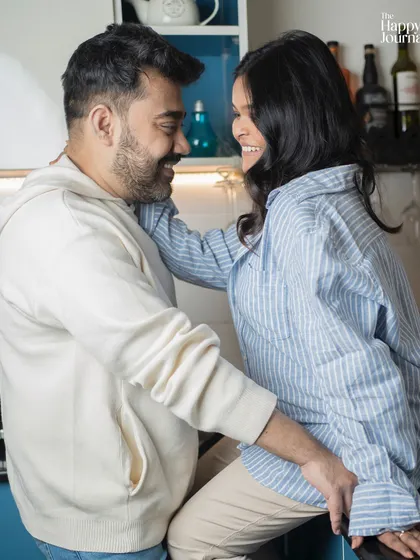 A playful and intimate moment in the kitchen. Casual, lifestyle-inspired shots like this capture the authentic connection and happiness of a couple expecting their child.