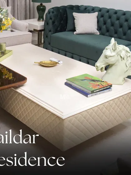A look at the custom Alba coffee table in the Zaildar Residence. Its quilted fabric base and clean top complement the deep green Chesterfield sofa, creating a space that is both refreshing and lush.