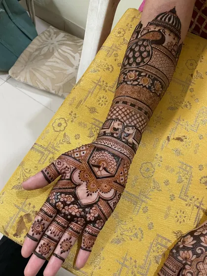 A detailed bridal design with peacocks, elephants, and floral motifs. The combination of fine lines and bold-filled areas creates a rich texture.