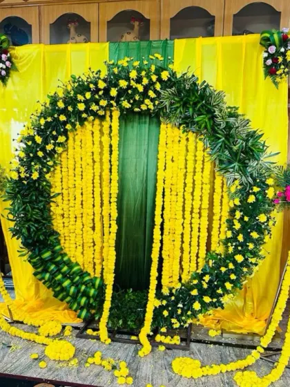 The complete Haldi setup with the marigold arch, yellow fabric backdrop, and floral stands.
