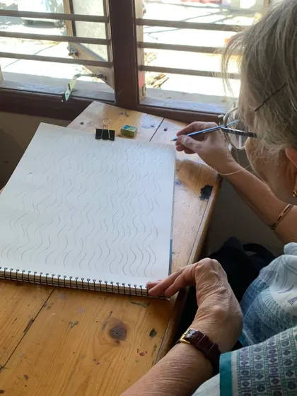 Our classes are open to everyone. Here, a senior student practices basic line work, proving that the desire to learn is timeless.