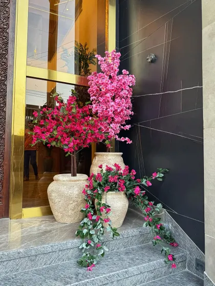Faux but make it pretty. This arrangement of artificial pink blossoms and bougainvillea in our rustic, textured pots is designed to make a statement and add a burst of color to the entrance.