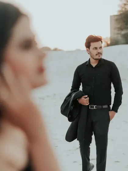 An artistic shot with the bride out of focus in the foreground, drawing the eye to the groom. This creative composition adds depth and a narrative feel to the photo series.