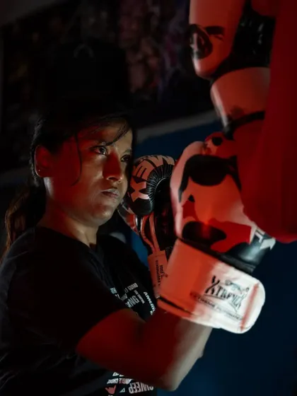 This shot captures the moment of impact during pad work. It's about channeling your strength into a focused, powerful strike. This kind of training builds both physical power and mental fortitude.