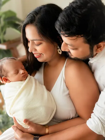 Another angle of the family embrace, capturing the mother's loving gaze and the father's protective hold.