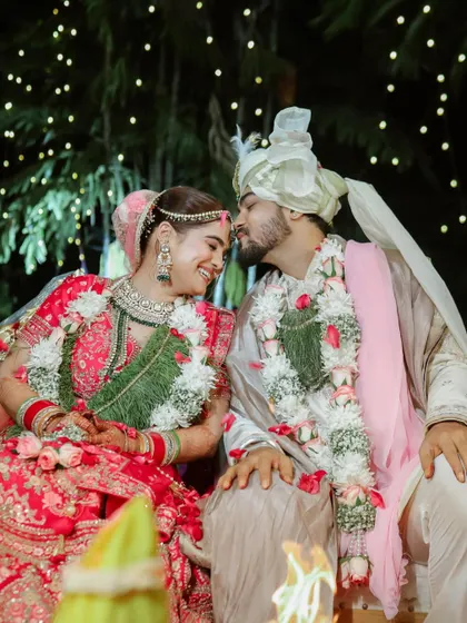 Sharing a happy, quiet moment together during their wedding ceremony. The fairy lights in the background add a touch of magic to this candid shot.