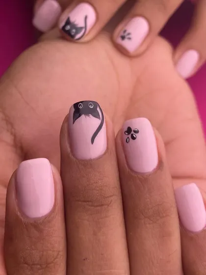 For the cat lovers, this adorable set features a peeking black cat and tiny paw prints on a soft pink base. It's a simple, cute, and charming hand-painted design.