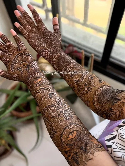 A classic full bridal mehendi with symmetrical patterns on both arms.