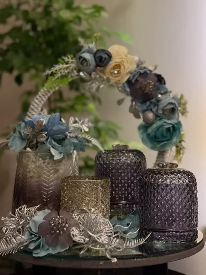 An evening of light and fragrance. This festive hamper features a cool blue and purple colour palette, with decorative jars and a floral-adorned basket handle, creating a serene and beautiful gift.