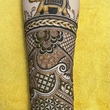 The full view of the elephant design, showing how it is integrated with intricate patterns to cover the entire arm.