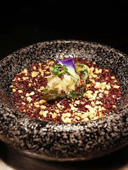 A dish of red rice with peanuts and a betel leaf wrap. This creation highlights our use of unique, healthy ingredients and our expertise in modern Asian cuisine.